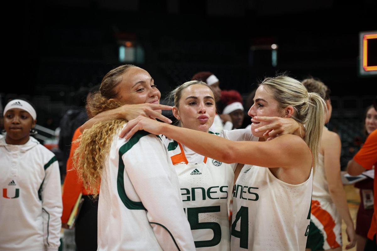 Hurricane’s Kenza Salgues (0), Hanna Cavinder (15) and Haley Cavinder (14) celebrate a 85-74 win against the University of Virginia on Sunday, Feb. 26, 2023, at the Watsco Center in Coral Gables.