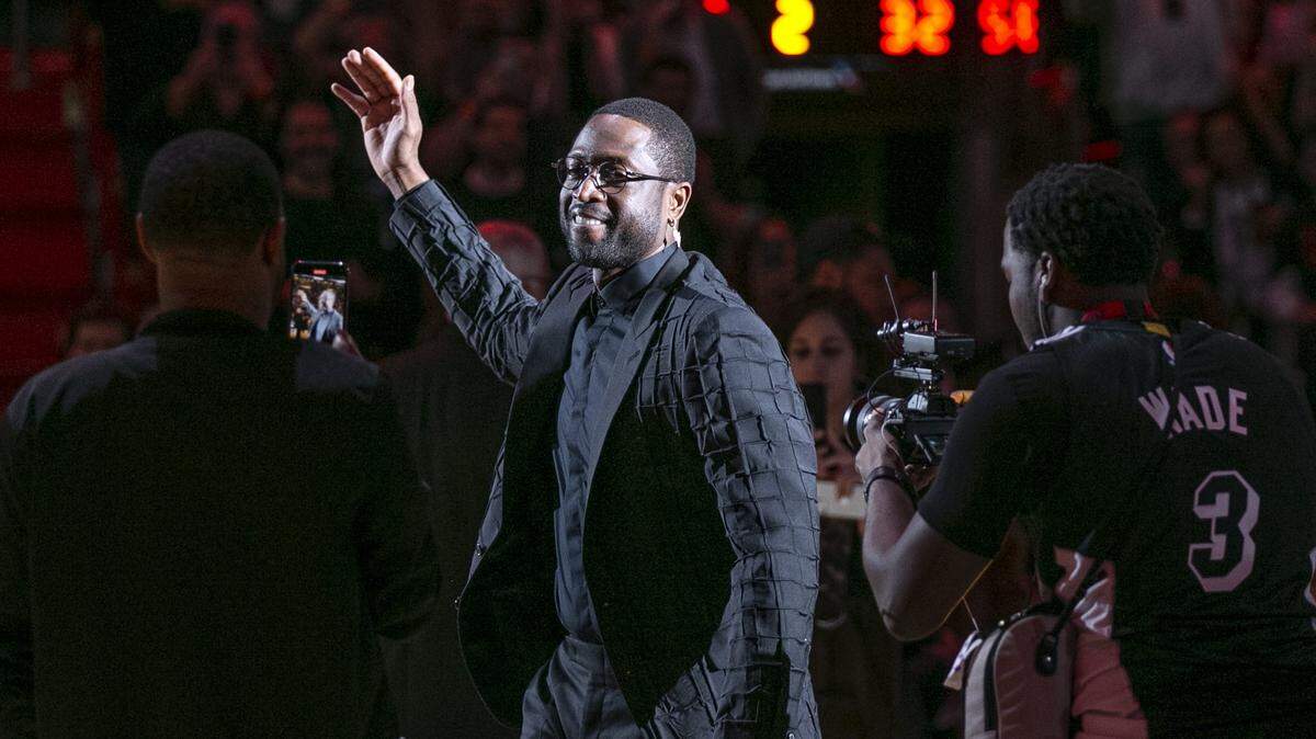 Former Miami Heat guard Dwyane Wade waves during a ceremony for his jersey-retirement at halftime as the Heat host against the Cleveland Cavaliers at AmericanAirlines Arena on Saturday, February 22, 2020.