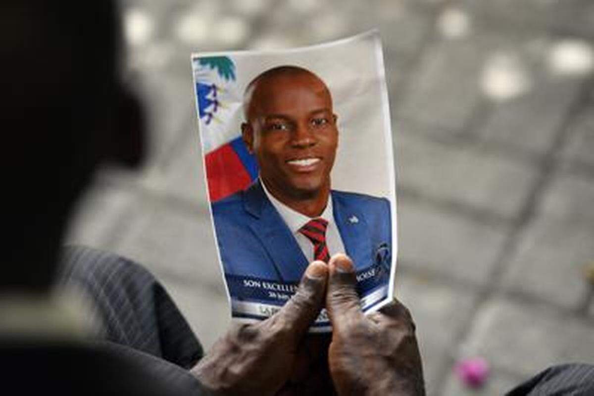 Un doliente sostiene una foto del difunto presidente haitiano Jovenel Moïse durante una ceremonia conmemorativa en el Museo Nacional del Panteón en Puerto Príncipe en julio de 2021.