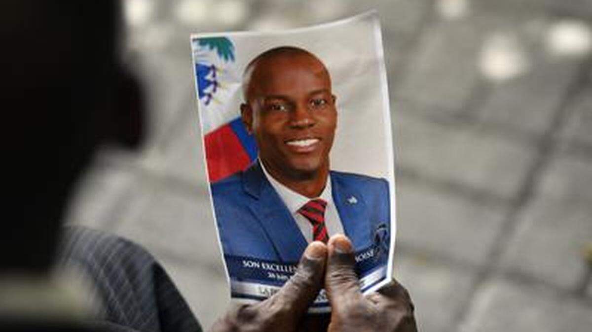 A mourner holds a photo of late Haitian President Jovenel Moïse during a memorial ceremony at the National Pantheon Museum in Port-au-Prince in July 2021.