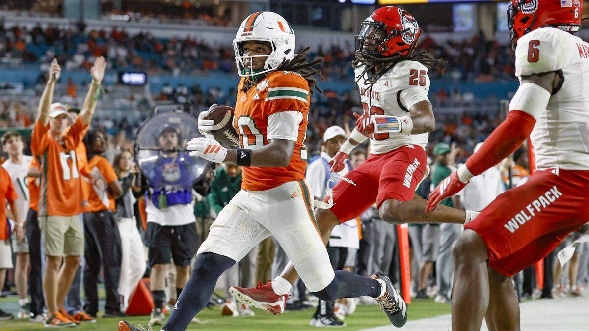 Miami Hurricanes wide receiver Malachi Toney (10) scores in the second half as NC State Wolfpack defensive back Asaad Brown Jr. (26) gives chase during an NCAA football game at Hard Rock Stadium in Miami Gardens, Florida, on Saturday, November 15, 2025.