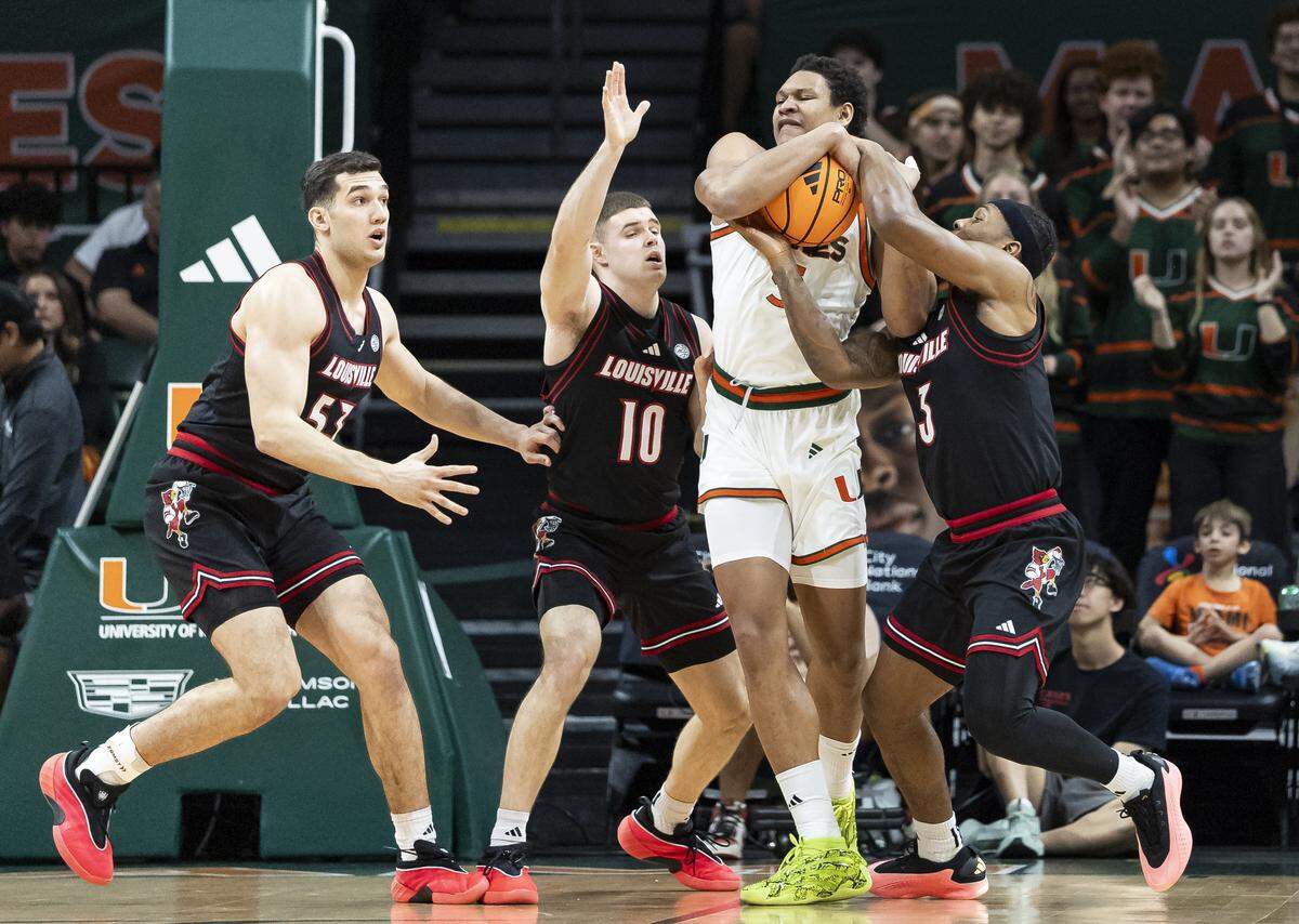 Miami Hurricanes forward Malik Reneau (5) fights for the ball against Louisville Cardinals guard Ryan Conwell (3) and guard Isaac McKneely (10) in the first half of their NCAA basketball game at the Watsco Center on Saturday, March 7, 2026, in Coral Gables, Fla.