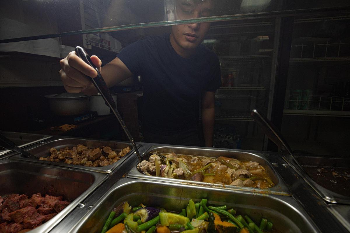 Matt Cardano explains the various Filipino foods at the buffet at Aklan Philippine Buffet in Miami, on Oct. 10, 2022.