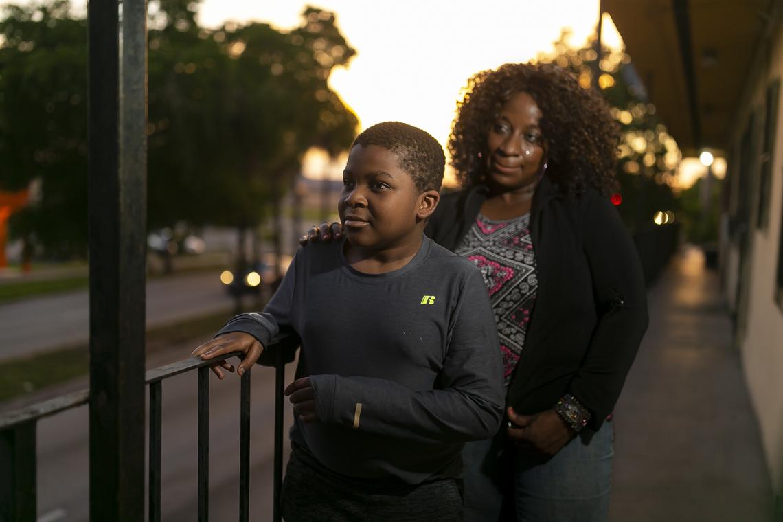 Timothy Nijon, 14, and his mother, Hetty Nyon, 45, stand outside their Liberty City apartment.