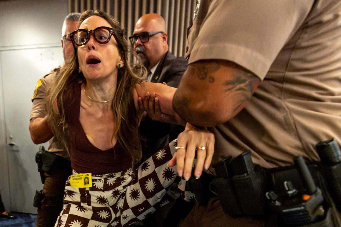 Camila Ramos is forcibly removed from the commission chambers by officers during a Miami-Dade County Commission meeting at the Stephen P. Clark Government Center on Thursday, June 26, 2025, in Miami.