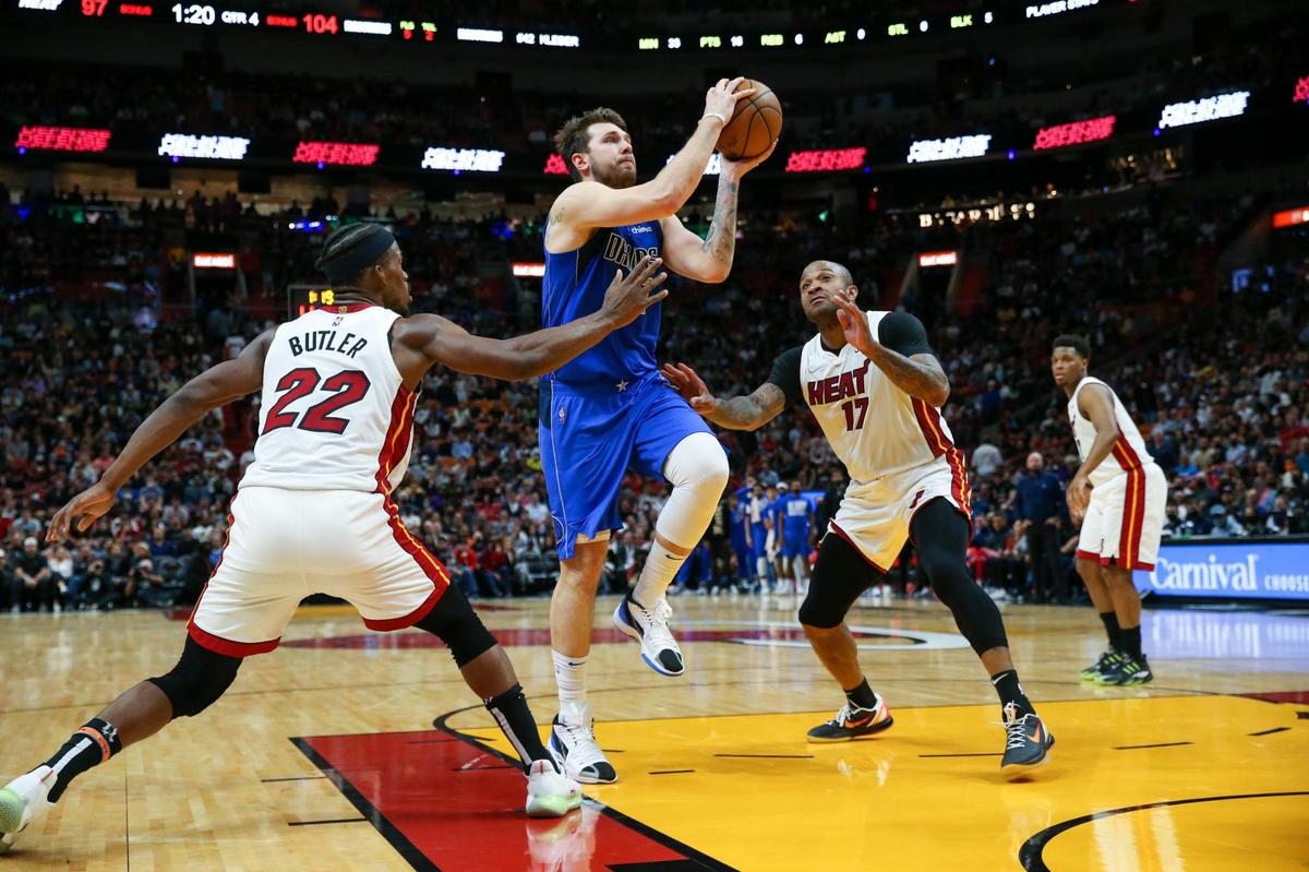 Dallas Mavericks guard Luka Doncic (77) goes to the basket against Miami Heat forward Jimmy Butler (22) and Heat forward P.J. Tucker (17) during the fourth quarter of their game at FTX Arena on Tuesday, February 15, 2022 in Miami.