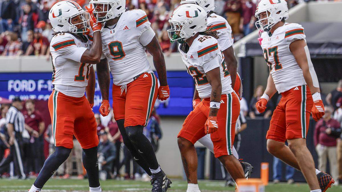 Miami Hurricanes tight end Elija Lofton (9) celebrates with teammates after scoring against the Virginia Tech Hokies in the first half at Lane Stadium in Blacksburg, Virginia, on Saturday, November 22, 2025.