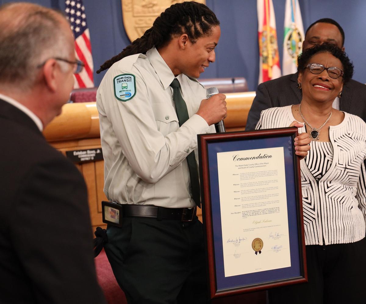Miami-Dade bus driver Elijah Saleem, center, received special recognition Tuesday from county commissioners, including Esteban Bovo, left, and Barbara Jordan, right, for rescuing a family whose car had plunged into a canal.