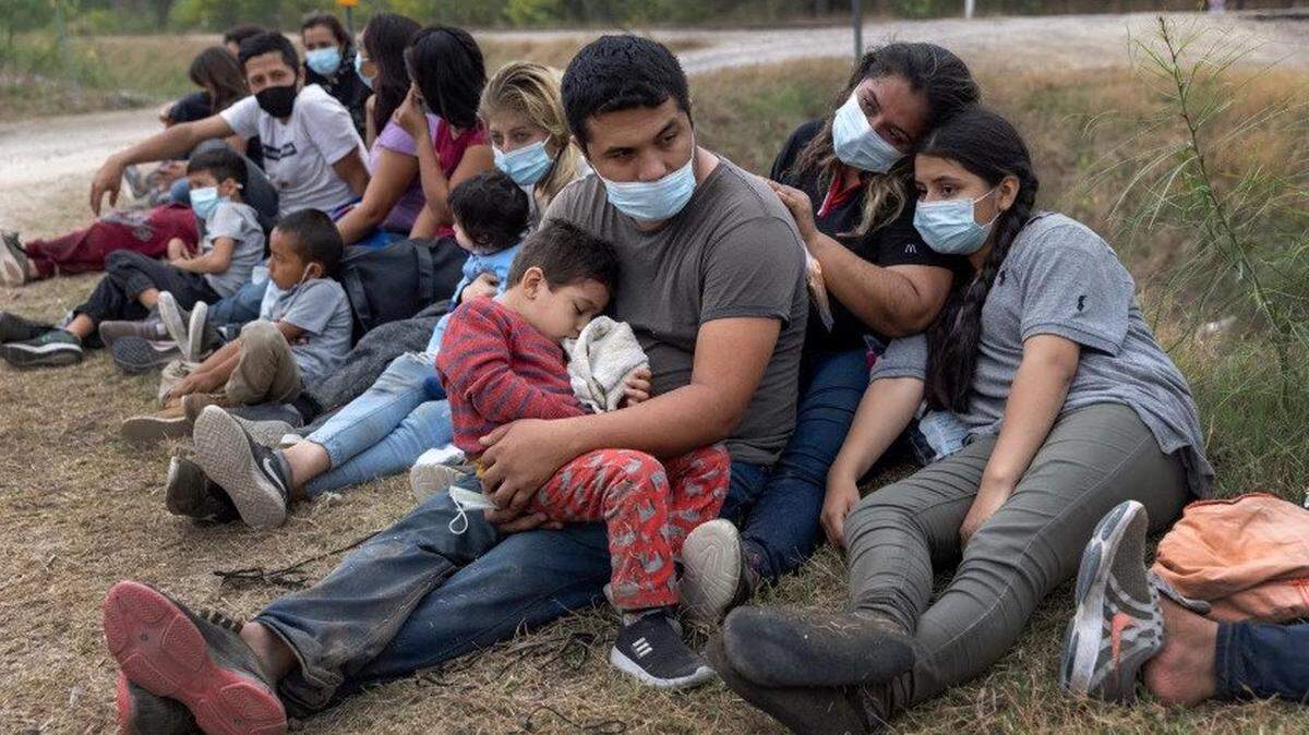 A Guatemalan family waits with other immigrants to board a U.S. Customs and Border Protection bus to a processing center after crossing the Mexican border into La Joya, Texas.