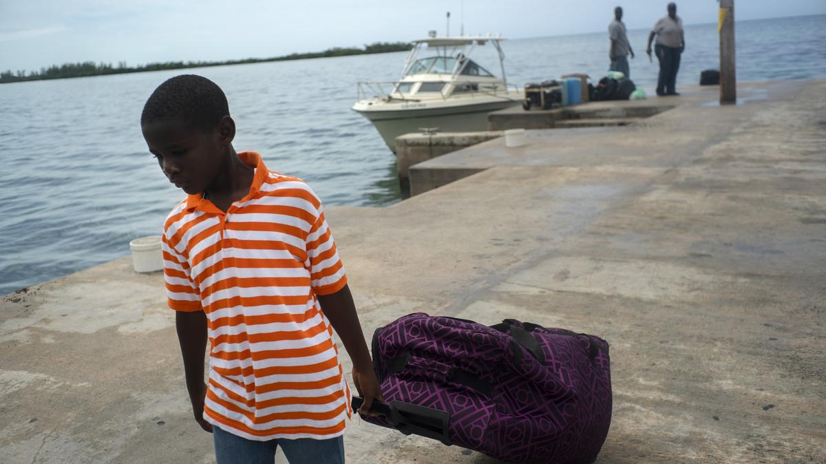A child evacuated from a nearby Cay due to the danger of floods drags his suitcase when he arrives on a ship at the port before the arrival of Hurricane Dorian in Sweeting’s Cay, Grand Bahama, Bahamas, Saturday Aug. 31, 2019. (AP Photo / Ramon Espinosa)