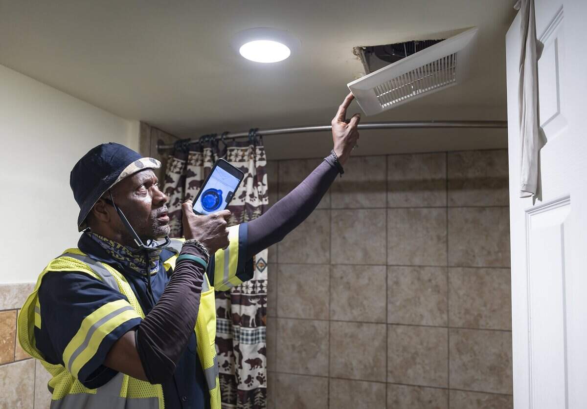 Ronnie McDonald, 62, a resident at Town Park Plaza South, opens the cover of his bathroom exhaust fan, where water leaked during a rainy day in June and caused damage to his home, while giving a tour of his apartment on Friday, May 8, 2026, in Miami, Fla. Residents of the Section 8 housing community in Overtown are currently living with leaks, mold, and damage inside their homes following a failed renovation project and the community has now filed a lawsuit against the design-builder/general contractor and its roofing subcontractor.