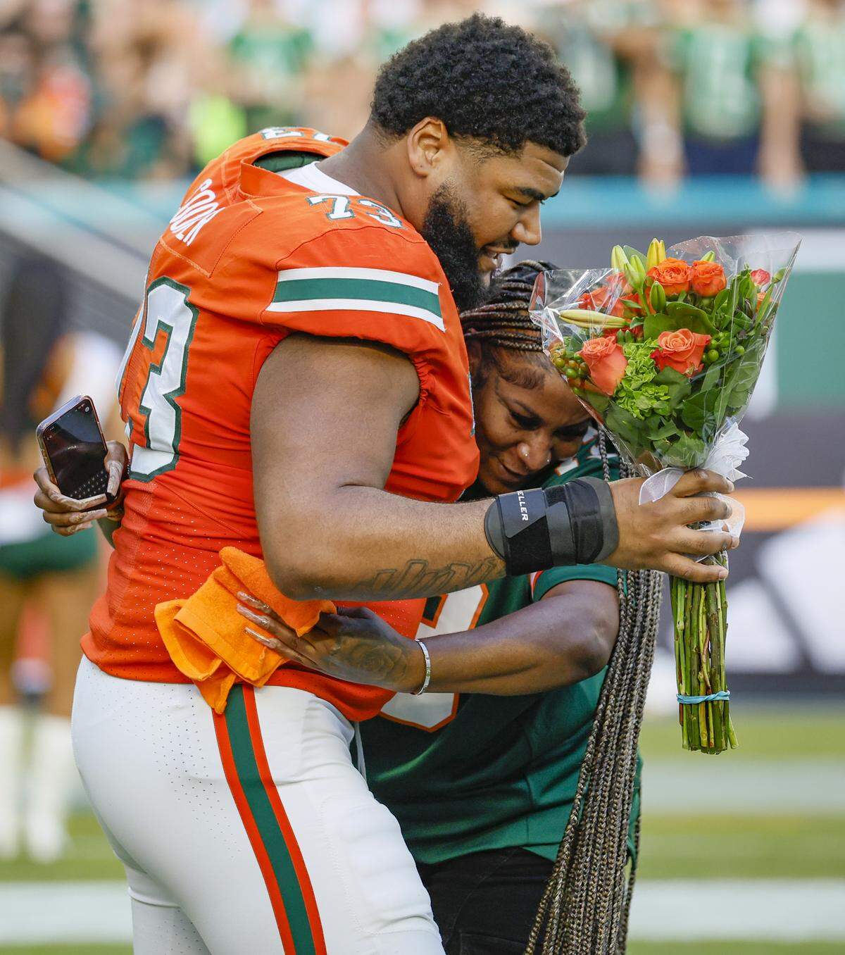 Miami Hurricanes offensive lineman Anez Cooper (73) is hugged by his mother Junea Cooper during Senior Day ceremony before the start of the NCAA game against the NC State Wolfpack at Hard Rock Stadium in Miami Gardens, Florida, on Saturday, November 15, 2025.