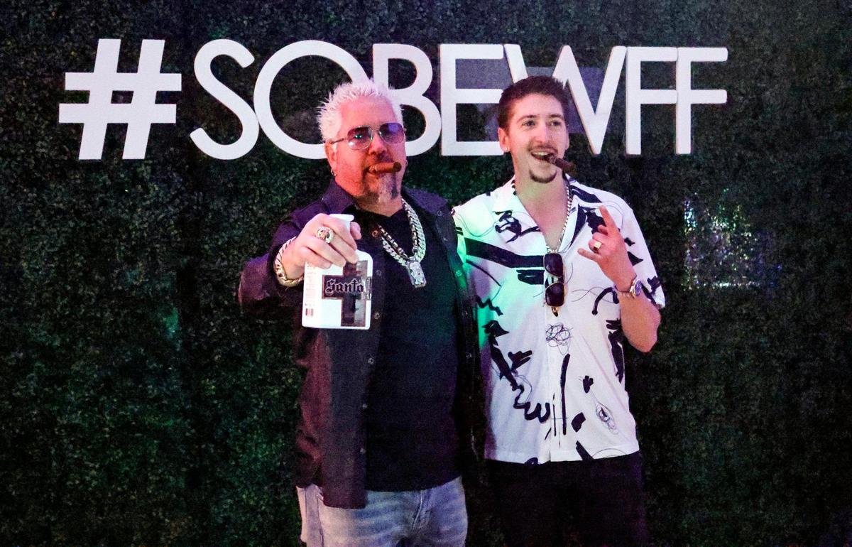Guy Fieri, chef and Food Network celebrity, with his son Hunter Fieri at South Beach Wine & Food Festival on the sand by the Ritz Carlton in Miami Beach, Florida, on Friday, Feb. 24, 2023.