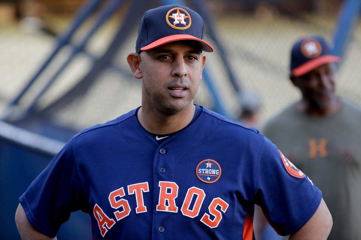 FILE - In this Oct. 23, 2017, file photo, Houston Astros bench coach Alex Cora watches batting practice during media day for baseball’s World Series against the Los Angeles Dodgers, in Los Angeles. Houston manager AJ Hinch and general manager Jeff Luhnow were suspended for the entire season Monday, Jan. 13, 2020, and the team was fined $5 million for sign-stealing by the team in 2017 and 2018 season. Commissioner Rob Manfred announced the discipline and strongly hinted that current Boston manager Alex Cora — the Astros bench coach in 2017 — will face punishment later. Manfred said Cora developed the sign-stealing system used by the Astros. (AP Photo/David J. Phillip, File)