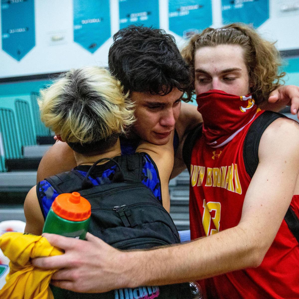 Miami Senior High School players Luis Sanchez Navarro, center, Gabriel Cabanzon, left, and South Broward High School player Colton Bueter embrace after the 2021 FHSAA Boys Volleyball Quarterfinals #3 at Archbishop McCarthy High School in Cooper City, Florida, on Friday, May 14, 2021.