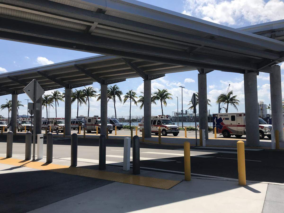 Ambulances from American Medical Response sit parked at Port Miami Thursday afternoon with engines running waiting for the cruise ships to arrive and bring ashore more than a dozen critical care patients.