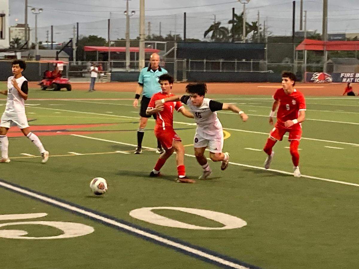 Ferguson midfielder Franchesco Del Aguila (15) battles Doral defenders for a loose ball during Wednesday’s Region 4-7A final at Doral Academy.
