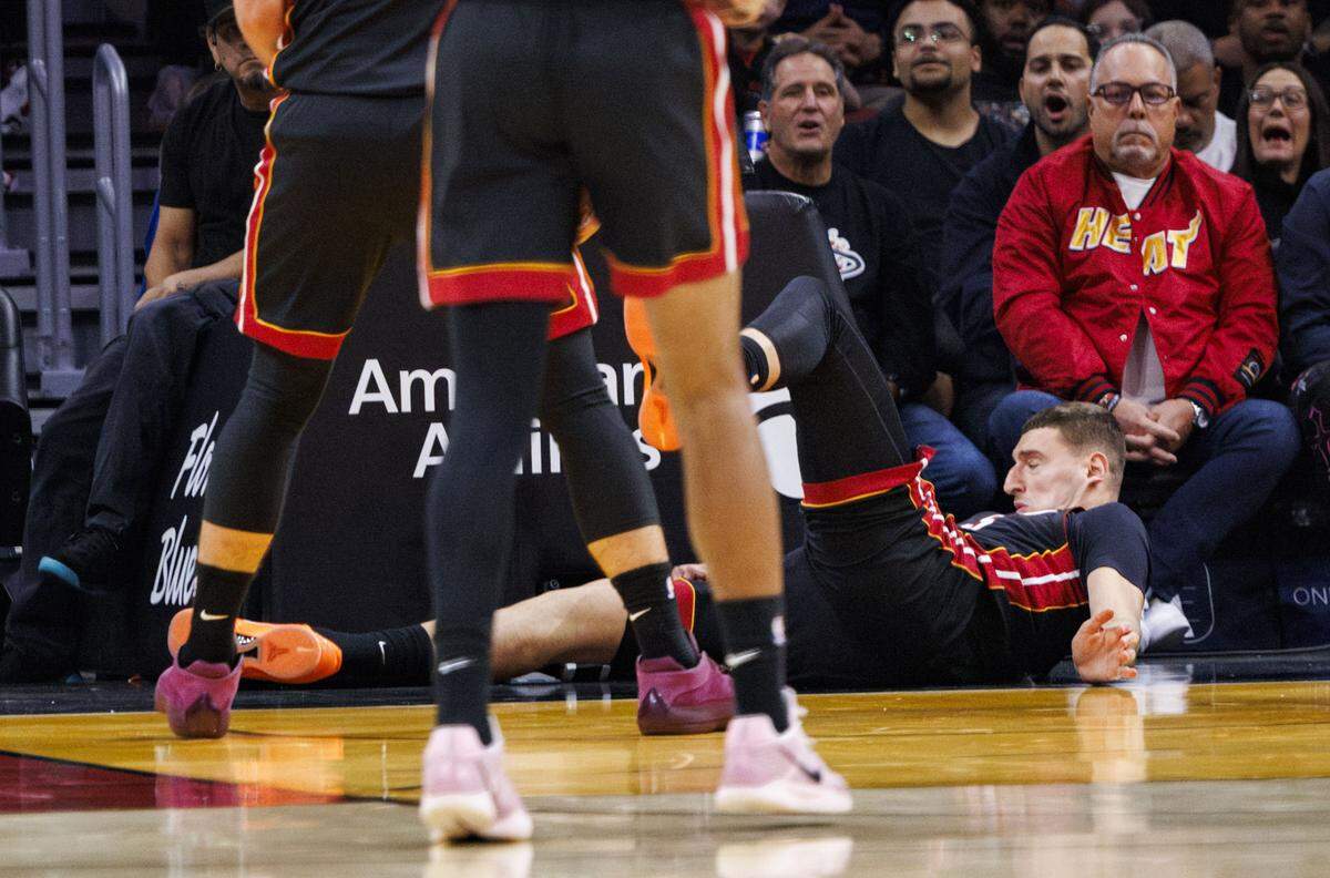 Miami Heat forward Nikola Jovic (5) falls to the floor injuring his right arm after being fouled by Toronto Raptors forward Collin Murray-Boyles (12) during the first half of a game on Dec. 15, 2025, at Kaseya Center in Miami.