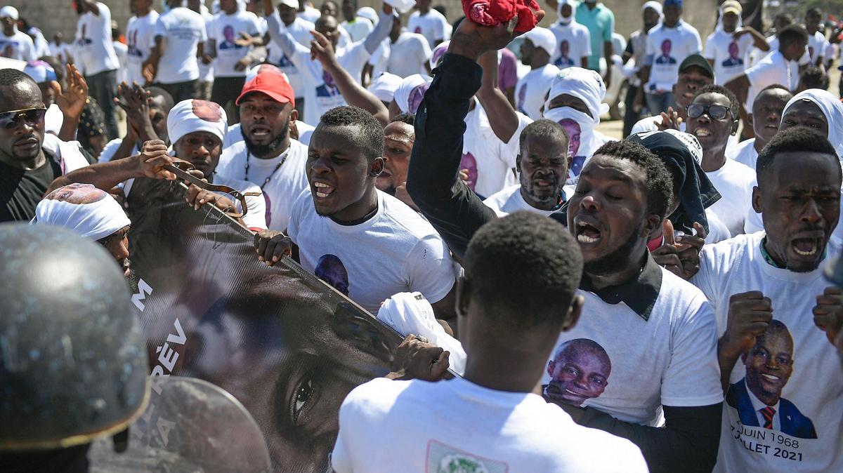 Supporters of slain Haitian President Jovenel Moïse are blocked from attending Moise’s funeral outside his family home as they call for justice in Cap-Haitien, Haiti, Friday, July 23, 2021. Moïse was assassinated at his home in Port-au-Prince on July 7.