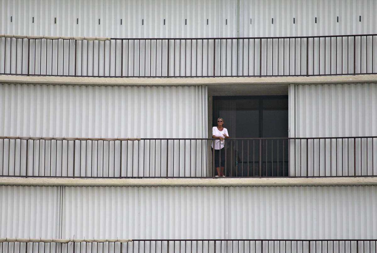 A Jupiter resident stands on her balcony among her many shuttered neighbors to get a better view of the weather while Hurricane Dorian finally began traveling north about 100 miles off the Florida Coast on Tuesday, September 3, 2019.