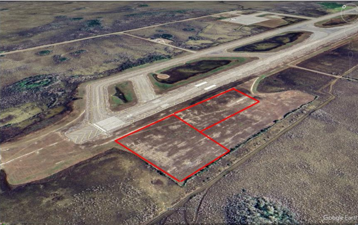 An aerial image of the site before any construction shows a “before” comparison with the newly paved area to the west of the runway.