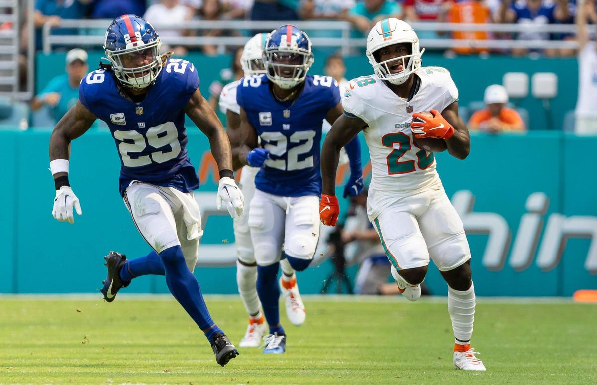 Miami Dolphins running back De’Von Achane (28) runs toward the goal line to score as New York Giants safety Xavier McKinney (29) tries to stop him in the second quarter of an NFL game at Hard Rock Stadium on Sunday, Oct. 8, 2023, in Miami Gardens, Fla.