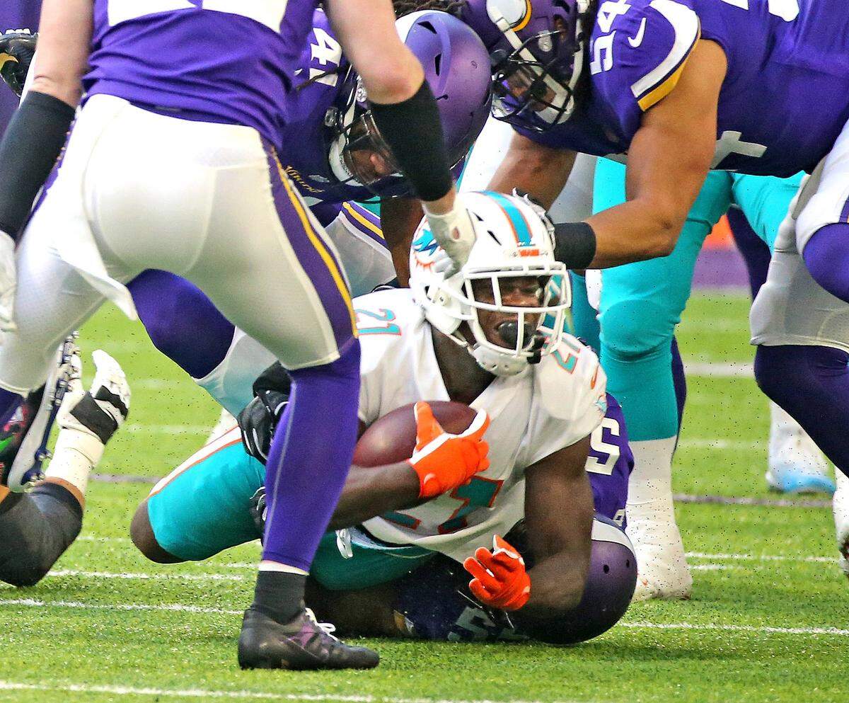 Miami Dolphins running back Frank Gore (21) reacts as Minnesota Vikings Anthony Barr falls on his ankle in the second quarter at U.S. Bank Stadium in Minneapolis, Sunday, December, 16, 2018.