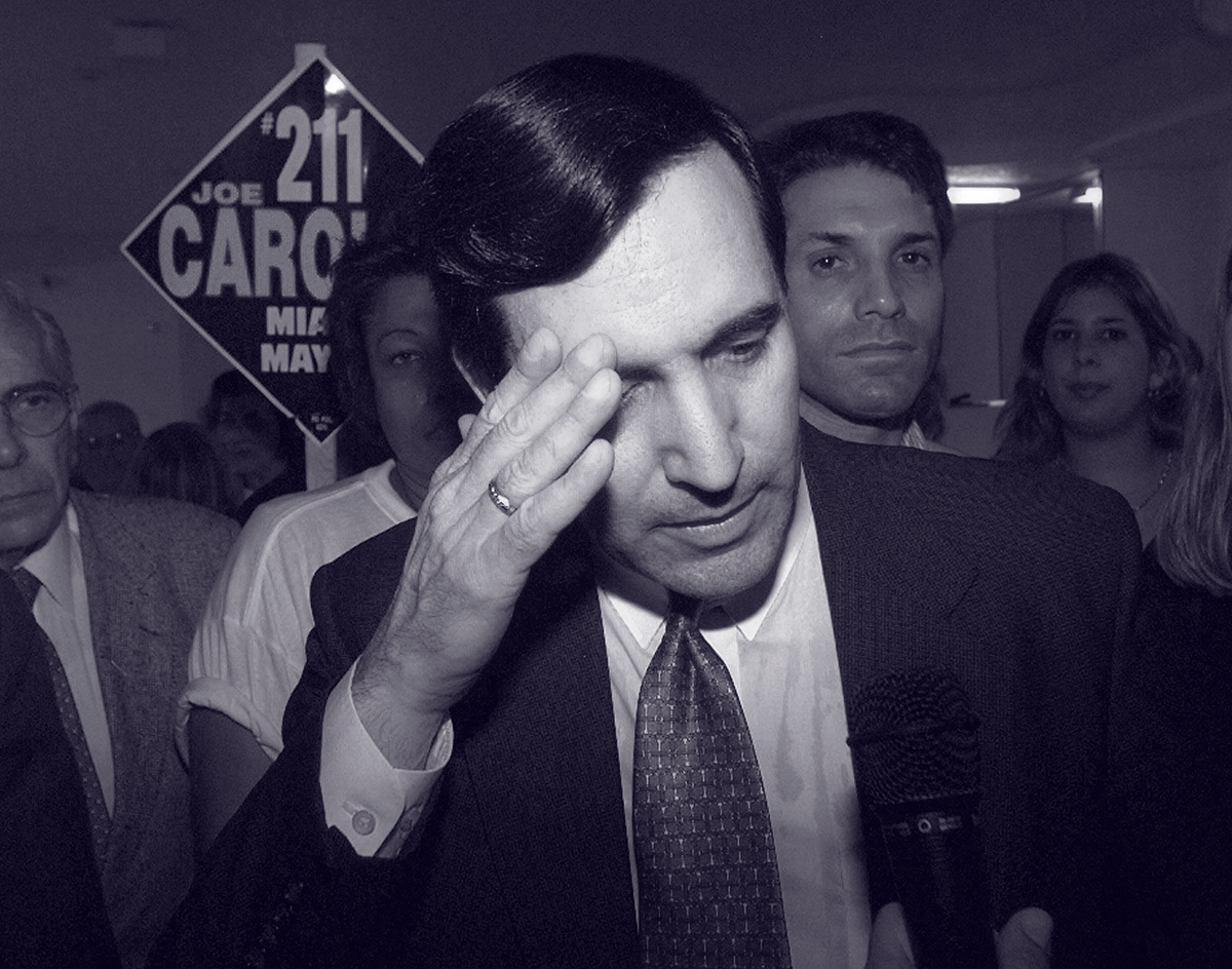 Joe Carollo hablando con los periodistas, rodeado de sombríos simpatizantes en la sede de su campaña luego de perder la segunda vuelta electoral en noviembre de 1997 frente a Xavier Suárez, padre del actual alcalde.
