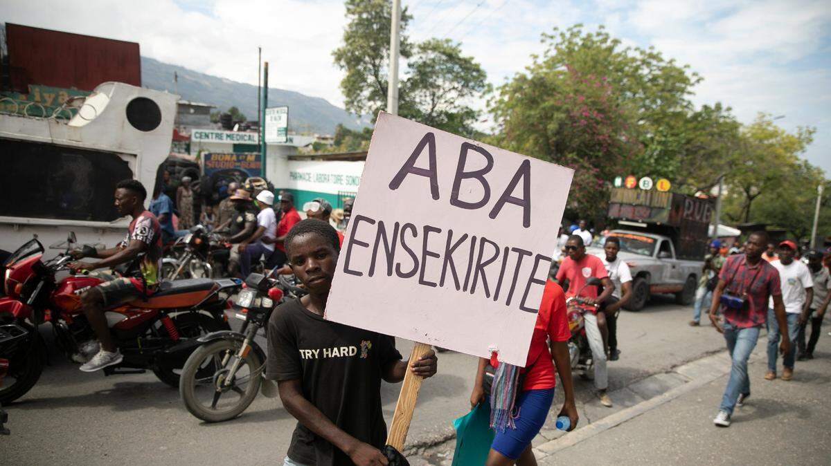 A man carries a sign that reads in Creole “Down with insecurity,” during a protest against increasing violence in Port-au-Prince, Haiti, Tuesday, March 29, 2022. The protest coincided with the 35th anniversary of Haiti’s 1987 Constitution and followed other protests and strikes in recent weeks in the middle of a spike in gang-related kidnappings.