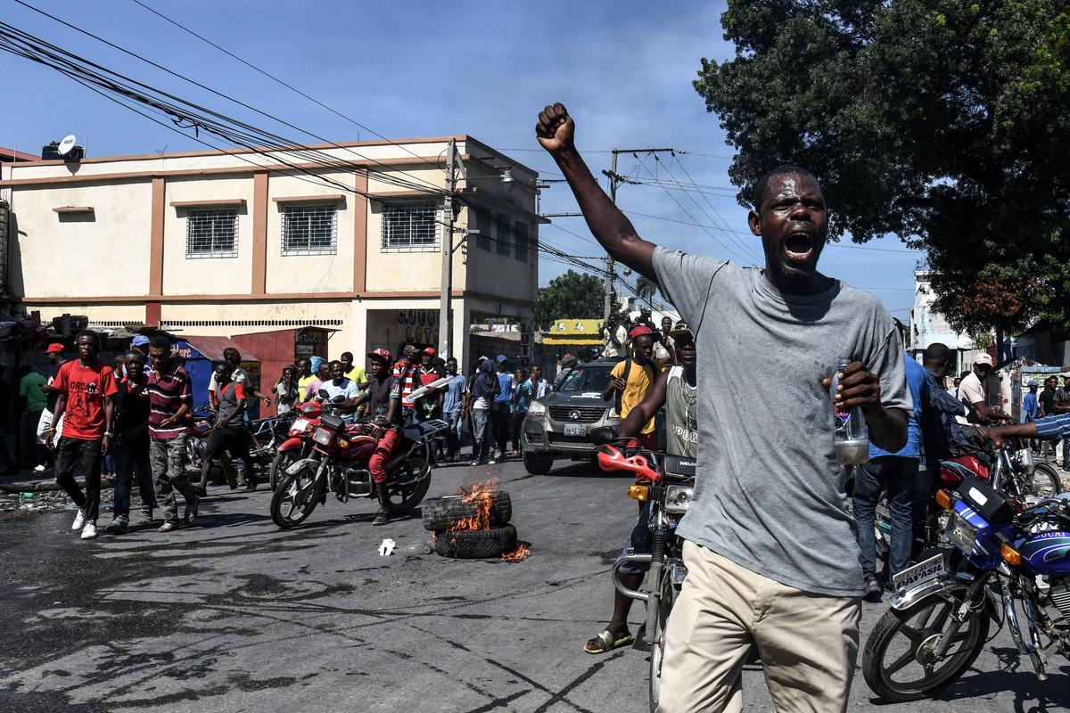 Demonstrators march on the street near parliament as they protest against the ruling government in Port-au-Prince, on September 23, 2019.