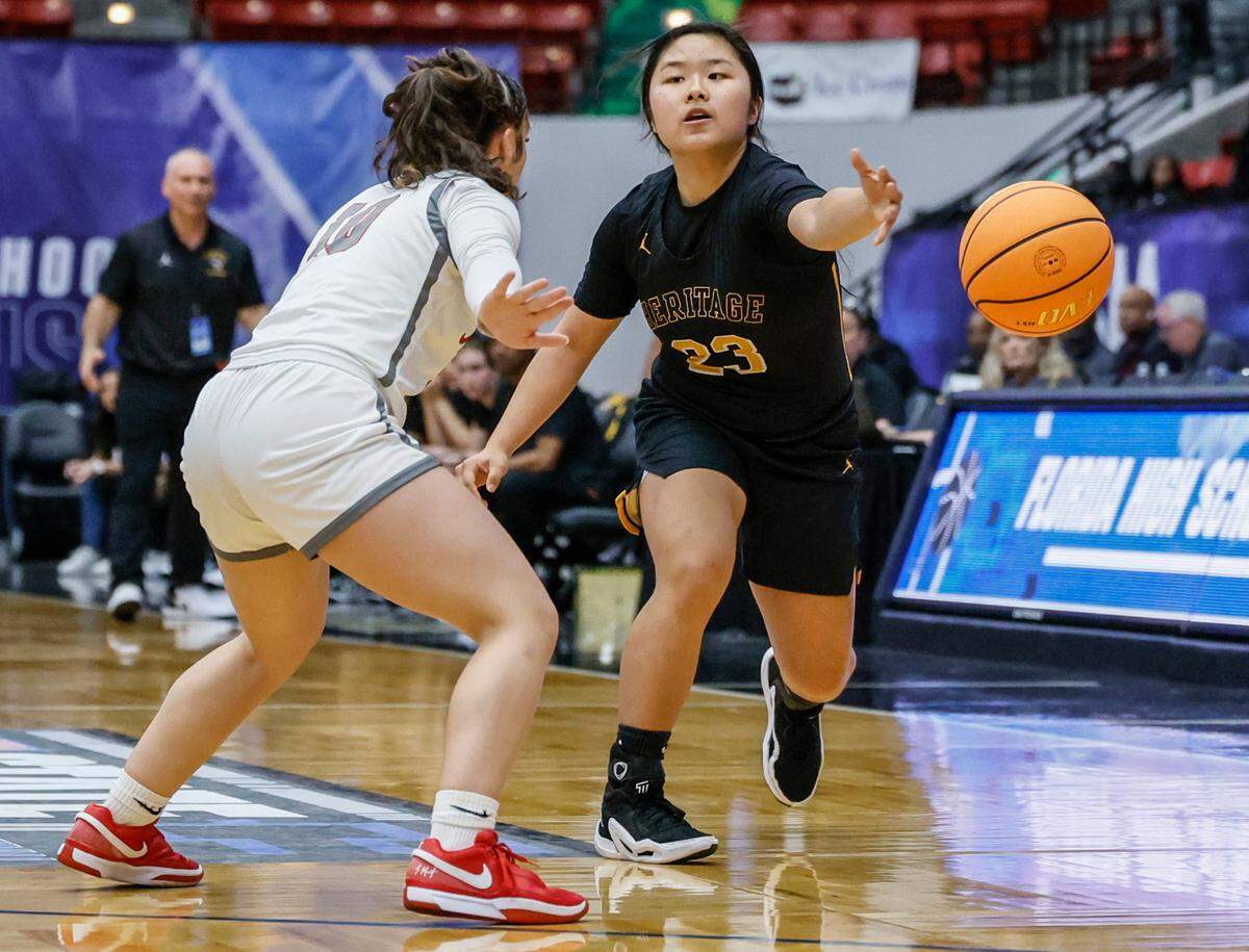 American Heritage’s Yinuo Wang (23) passes the ball as Palm Bay’s Gaby Buigues (10) defends in the first half of the FHSAA Class 4A Girls High School Basketball State Championship