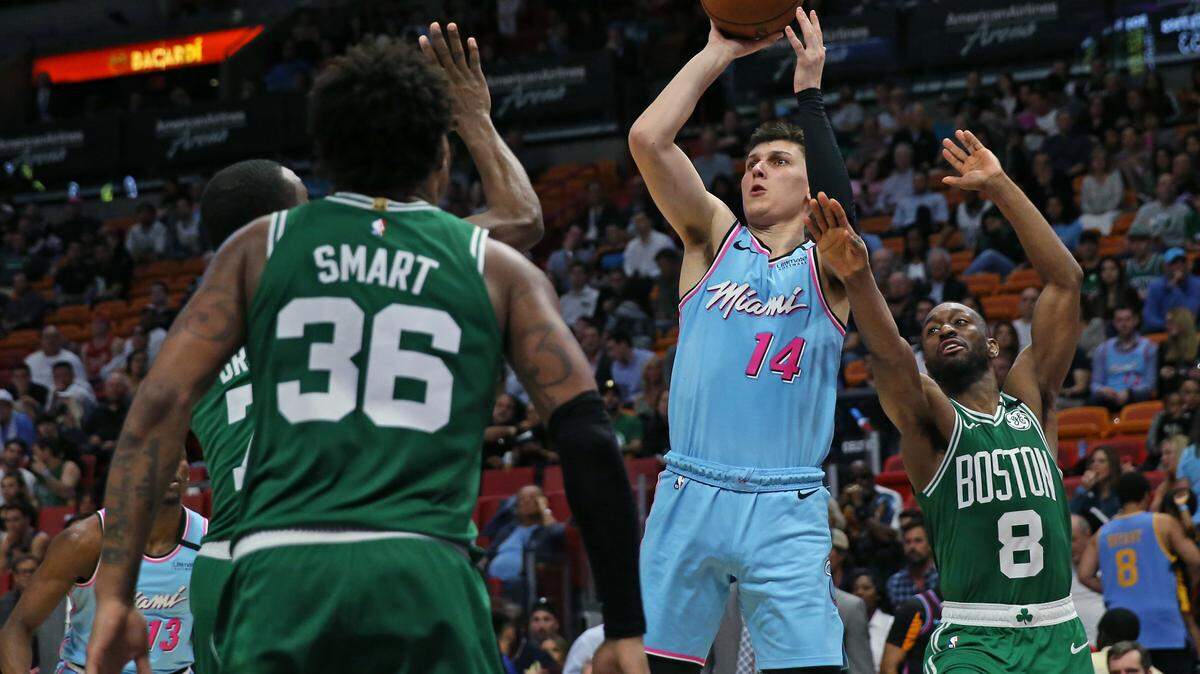 Miami Heat guard Tyler Herro (14) shoots over Boston Celtics guard Jaylen Brown (7) Marcus Smart (36) and Kemba Walker (8) in the third quarter of an NBA basketball regular season game at the AmericanAirlines Arena on Tuesday, January 28, 2020 in Miami.