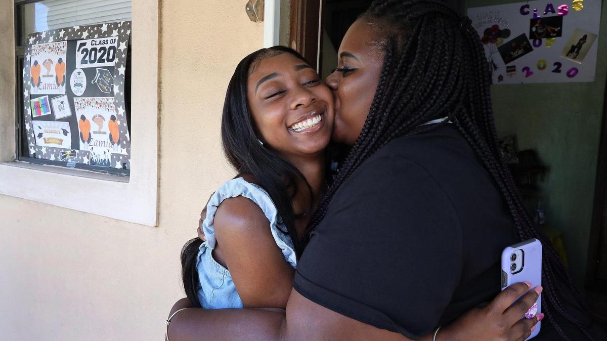 Graduating senior at Booker T. Washington High Zamiah Wadley, left, and mother, Luria Davis, embrace for a portrait after receiving a surprised scholarship from Biscayne Bay Kiwanis Club to attend college at Bethune-Cookman University.