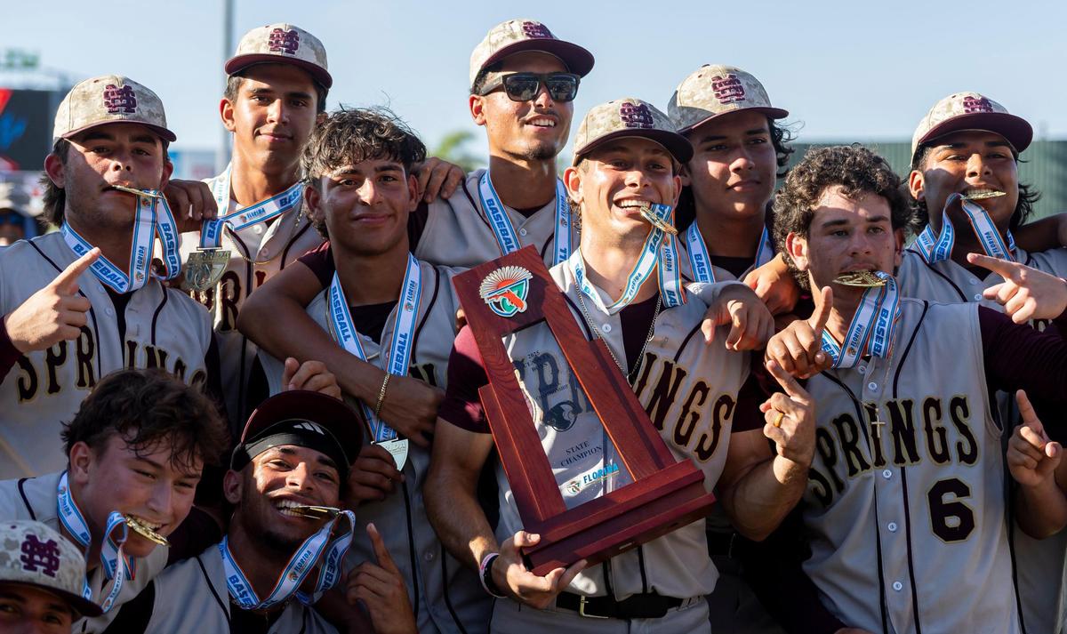 The Miami Springs Golden Hawks celebrate with the trophy after winning their first ever state baseball championship game at Hammond Stadium on Tuesday, May 20, 2025, in Fort Myers, Fla.