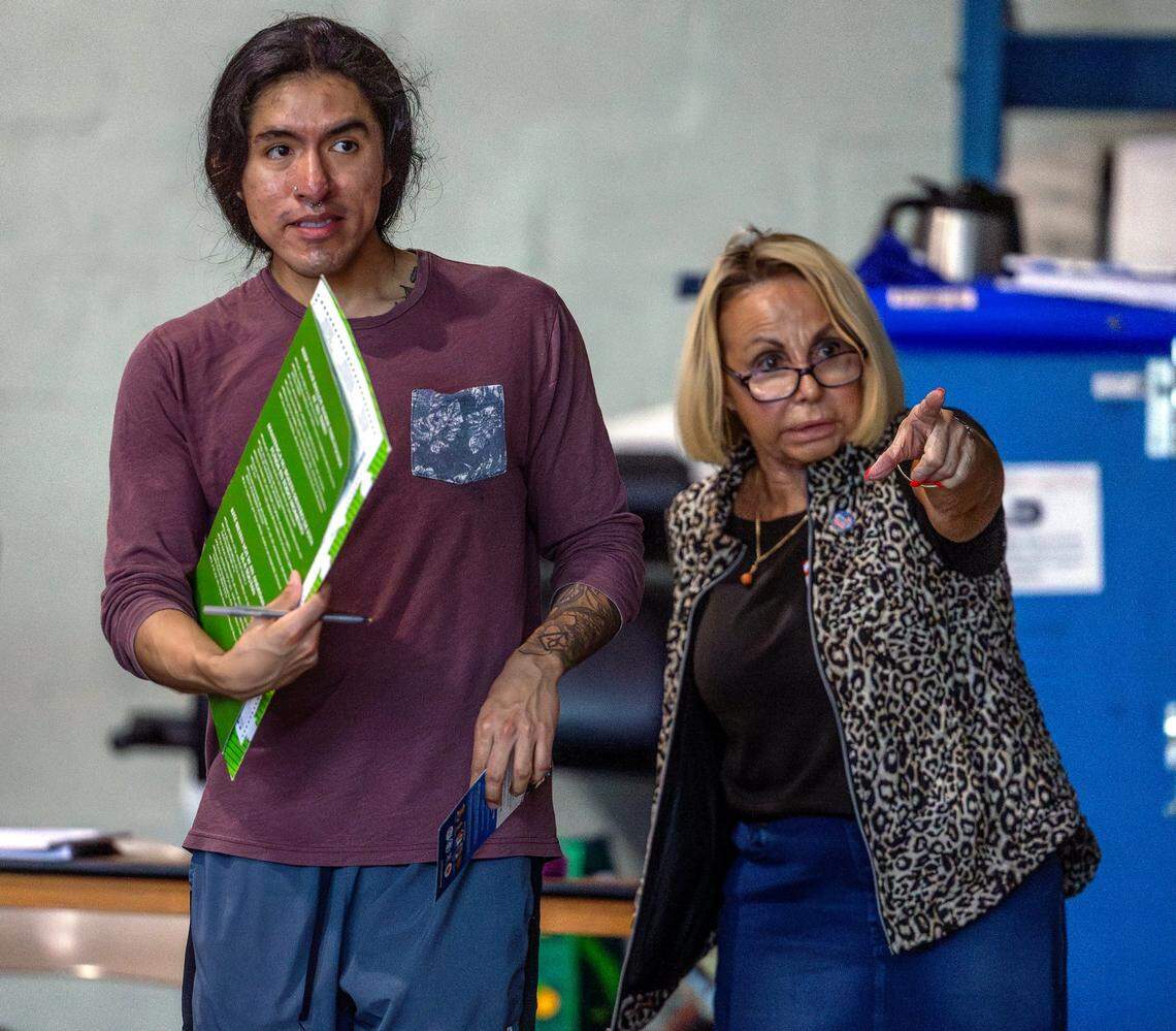 A polling worker helps a voter during the general Election in Miami-Dade County at the Miami Beach Fire Station #4 on Tuesday, Nov. 5, 2024, in Miami Beach, Fla.