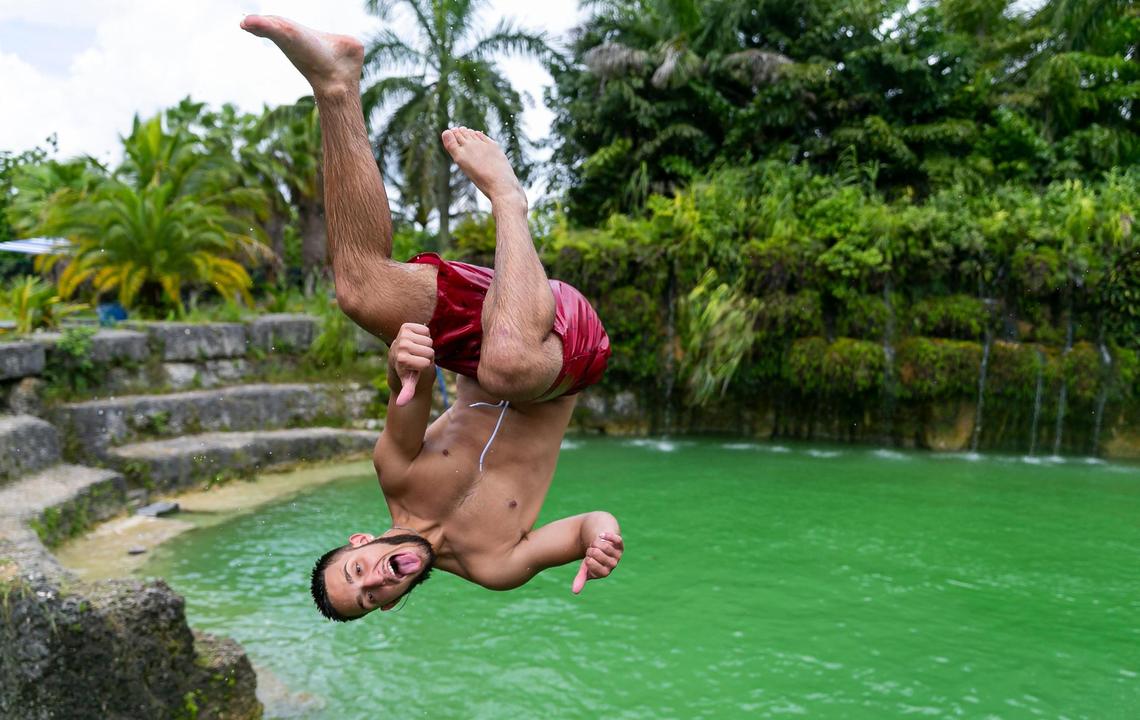Addiel Gil, 18, jumps into a pool at Blue Lagoon Farm Miami.