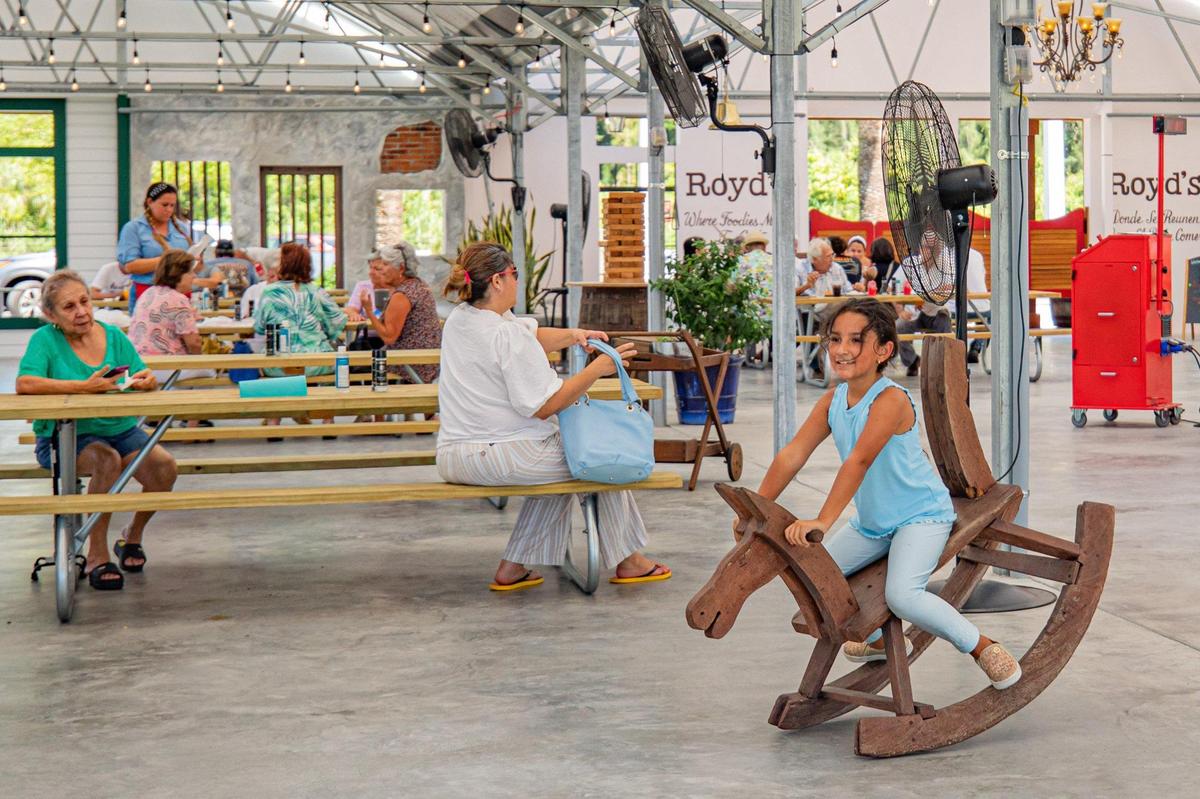 Una clienta monta un caballo de madera en la zona de juegos infantiles mientras la gente disfruta del ambiente en Royd's. Sydney Walsh swalsh@miamiherald.com