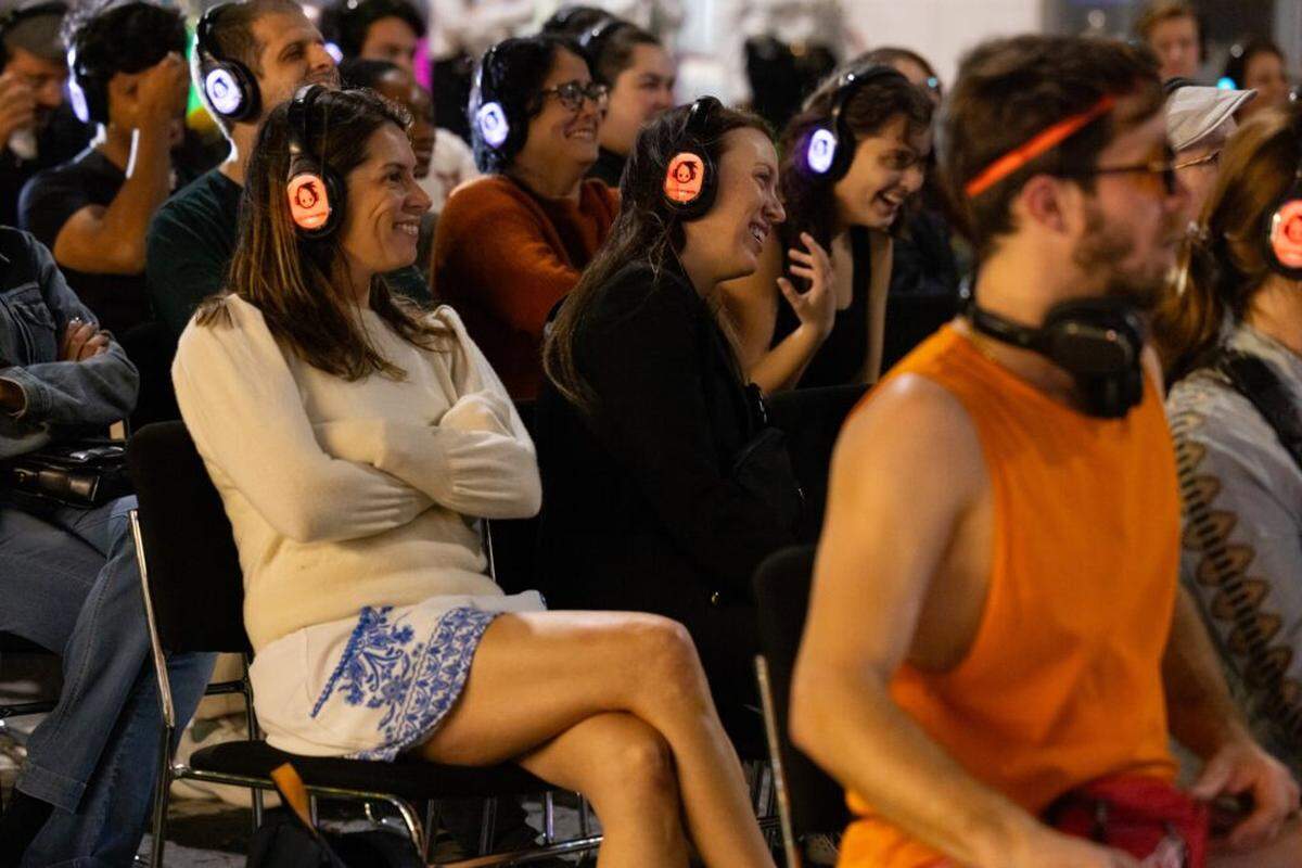 Audience members wear headphones to hear the action while watching “Lincoln Road Hustle” by Miami New Drama, which takes place along Lincoln Road.