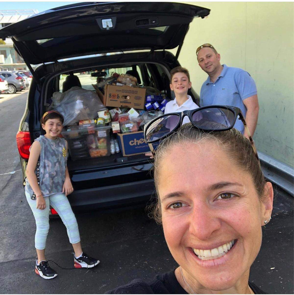 Rachel Unger and her husband Michael Feldman use Hanukkah to teach their children about social justice. Here they are pictured collecting donated food to bring to Lotus House.