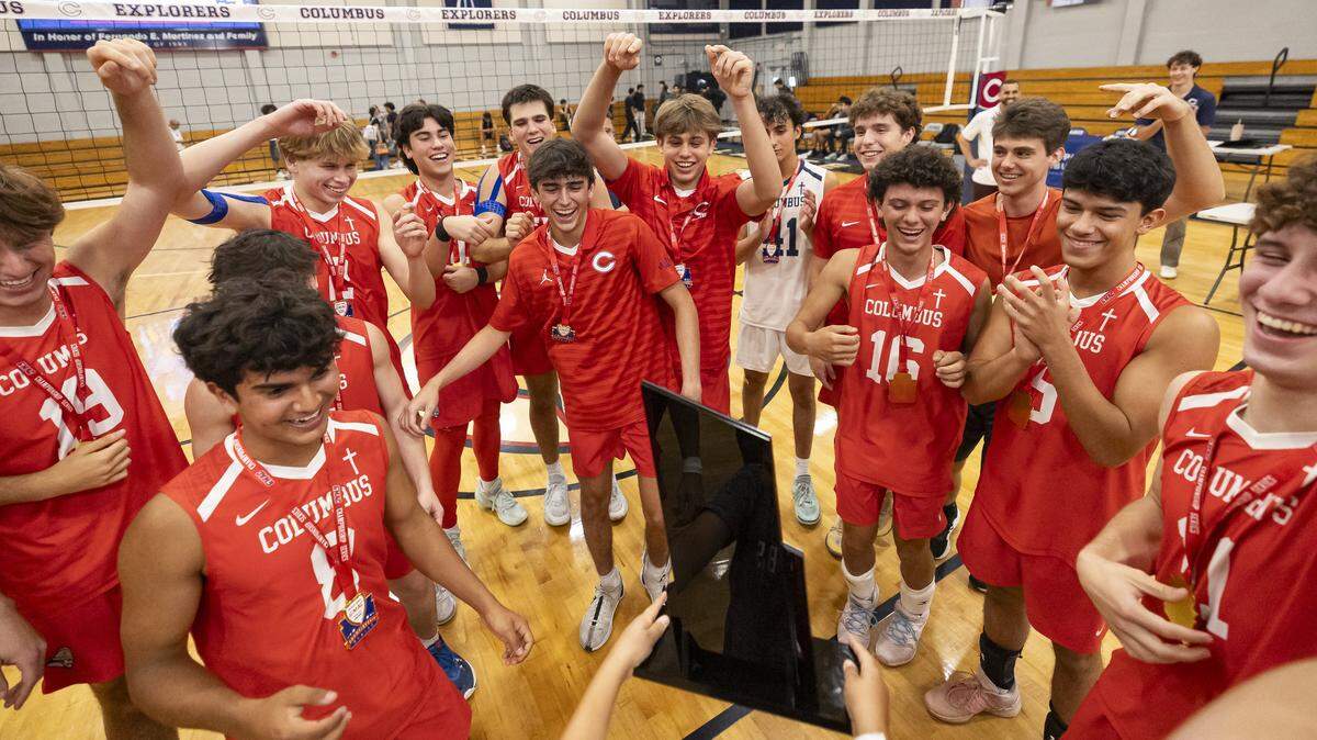 Andrew Ruiz, 8, the brother of Columbus Explorers Sebastian Ruiz (3), presents the team their trophy after they defeated the Varela Vipers in their GMAC volleyball tournament championship match at Christopher Columbus High School on Thursday, April 9, 2026, in Miami, Fla.