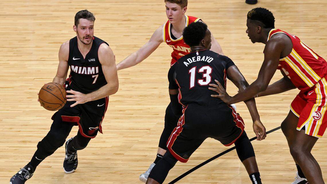 Miami Heat guard Goran Dragic (7) drives around the screen from teammate Bam Adebayo (13) as Atlanta Hawks guard Kevin Huerter (3) and Clint Capela (15) defend in the second half of their NBA game in Miami on February 28, 2021.