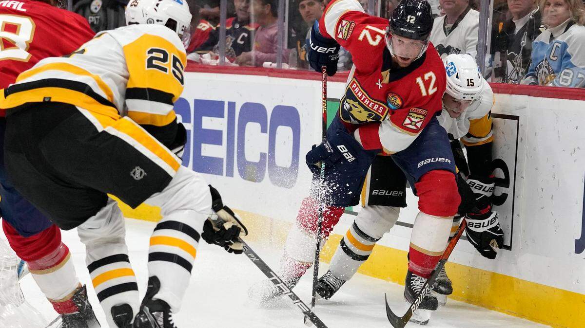 Florida Panthers center Eric Staal (12) goes for the puck against Pittsburgh Penguins center Ryan Poehling (25) and right wing Josh Archibald (15) during the first period of an NHL hockey game, Thursday, Dec. 15, 2022, in Sunrise, Fla. (AP Photo/Lynne Sladky)