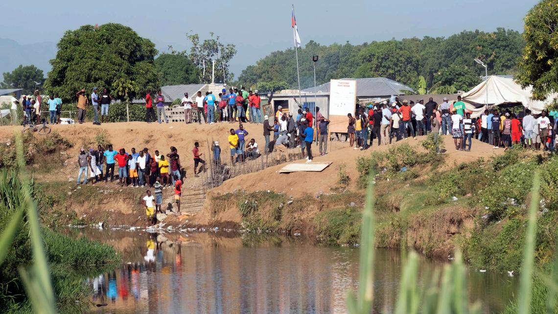 People stand near the construction of a canal, on the bank of the Massacre River, a natural border between Haiti and the Dominican Republic, photographed from Dajabon, Dominican Republic, Friday, Sept. 15, 2023. The Dominican Republic shut all land, air and sea borders with Haiti on Friday in a dispute about construction of a canal on Haitian soil that taps into the shared river.