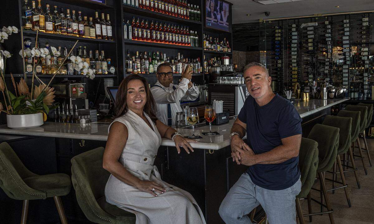 Bartender Christian Perez prepares drinks for owners and founders Elizabeth and George Iglesias, at the bar of George’s in North Beach.