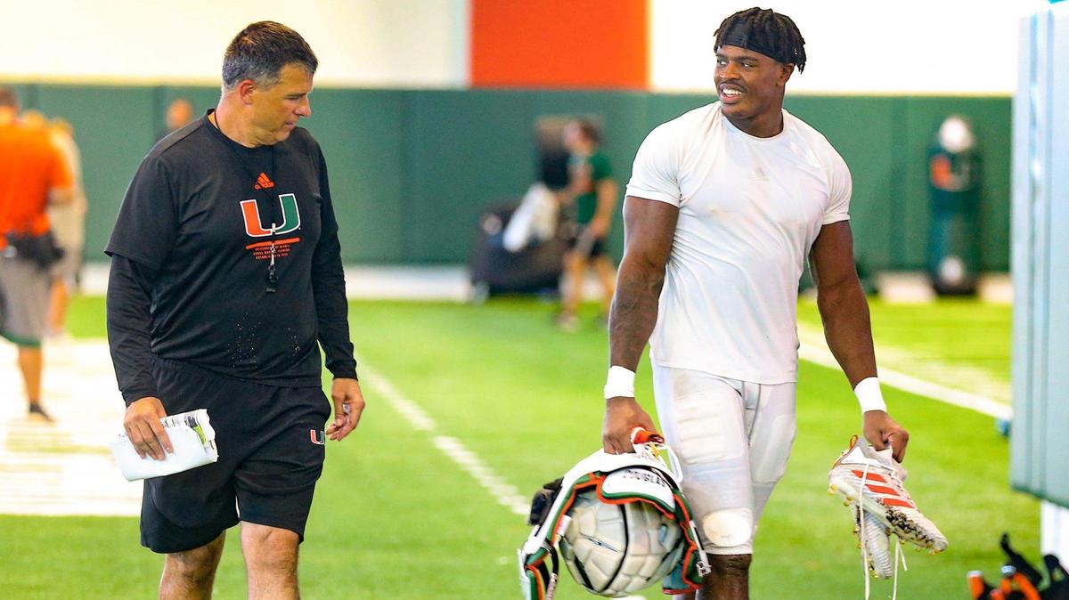 Miami Hurricanes coach Mario Cristobal walks with defensive end Mitchell Agude (45) in the Carol Soffer Indoor Practice Facility at the University of Miami in Coral Gables on Wednesday, August 24, 2022.