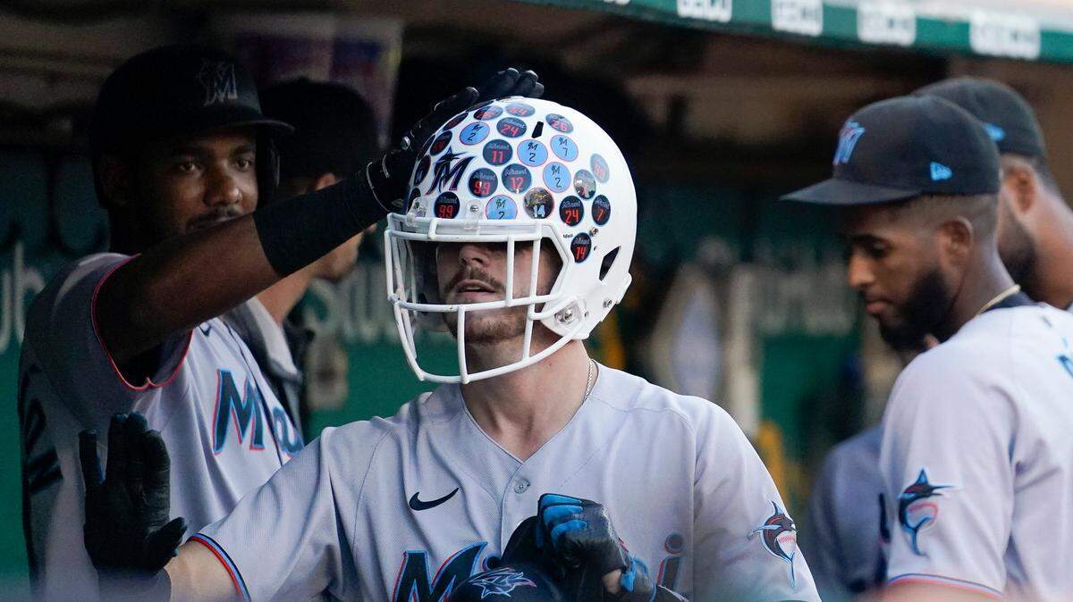 Miami Marlins’ Brian Anderson, center, celebrates in the dugout with teammates after hitting a solo home run against the Oakland Athletics during the fourth inning of a baseball game in Oakland, Calif., Tuesday, Aug. 23, 2022. (AP Photo/Godofredo A. VÃ(degrees)squez)