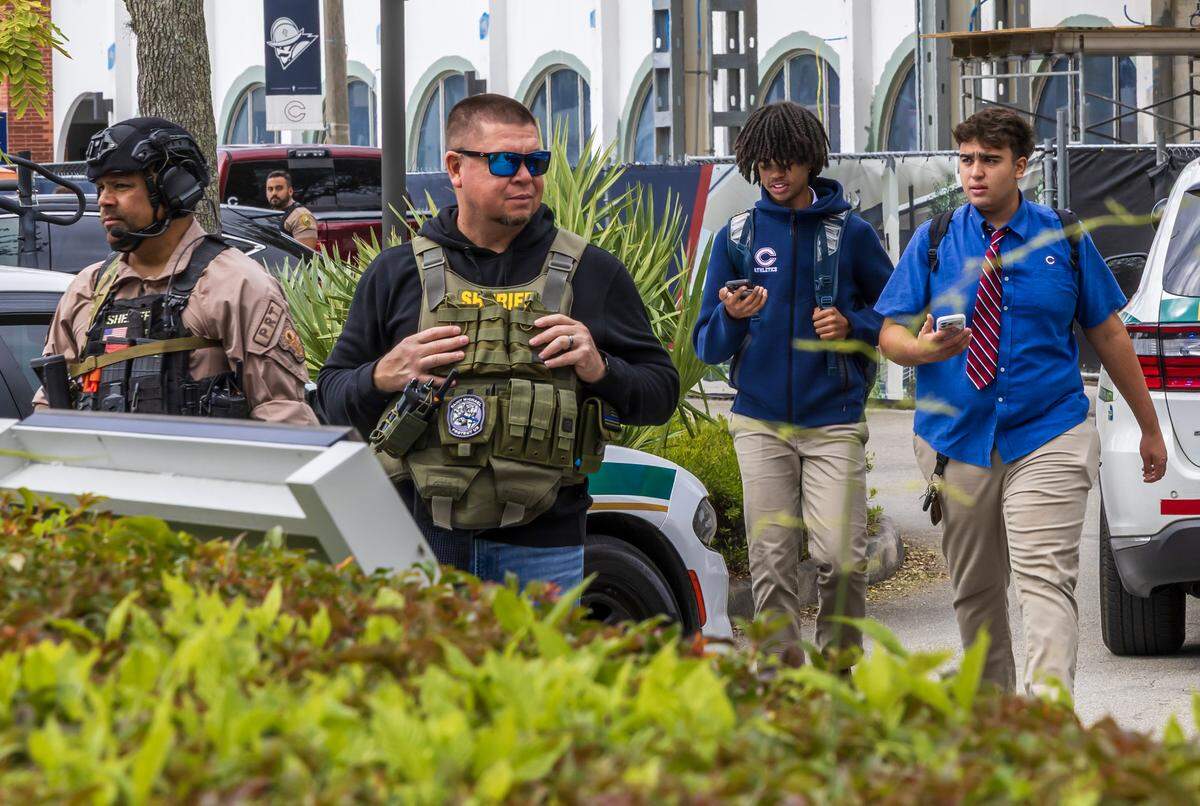 Students walk by Miami-Dade Sheriff’s Office deputies as they respond to a threat made to Christopher Columbus High School on Southwest 87th Avenue on Wednesday morning, Feb. 4, 2026, in Miami. Authorities said the call was a false alarm that prompted a lockdown at the school, and everyone was safe.