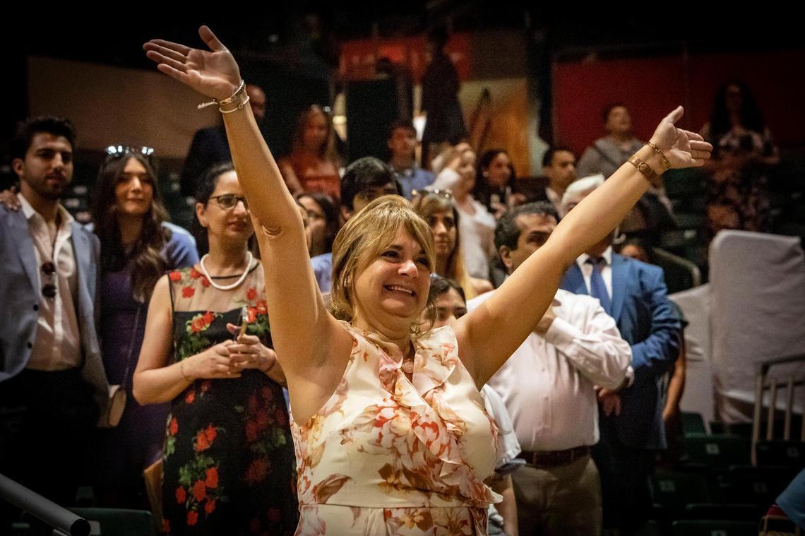 Ana Schecker waves to her daughter, Maria Laura Garcia, as she walks into the University of Miami graduation ceremony on Friday morning in Coral Gables.