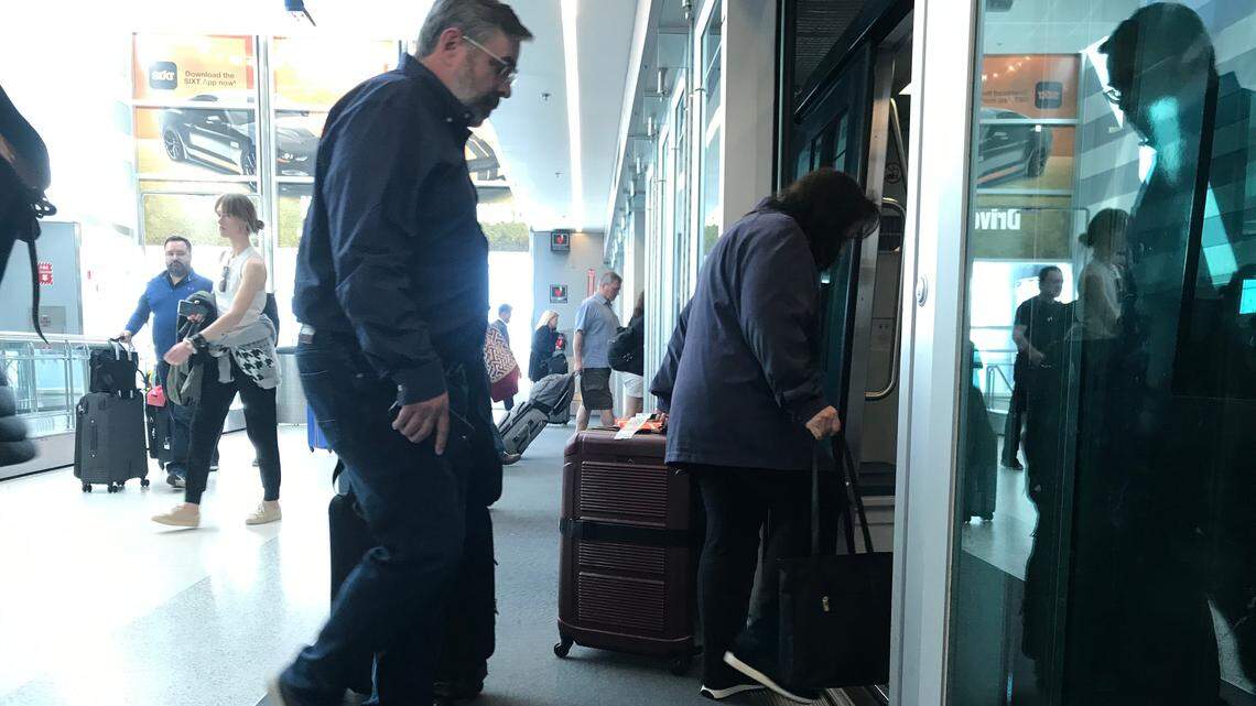 Airport passengers make connections at the Miami airport transit station.