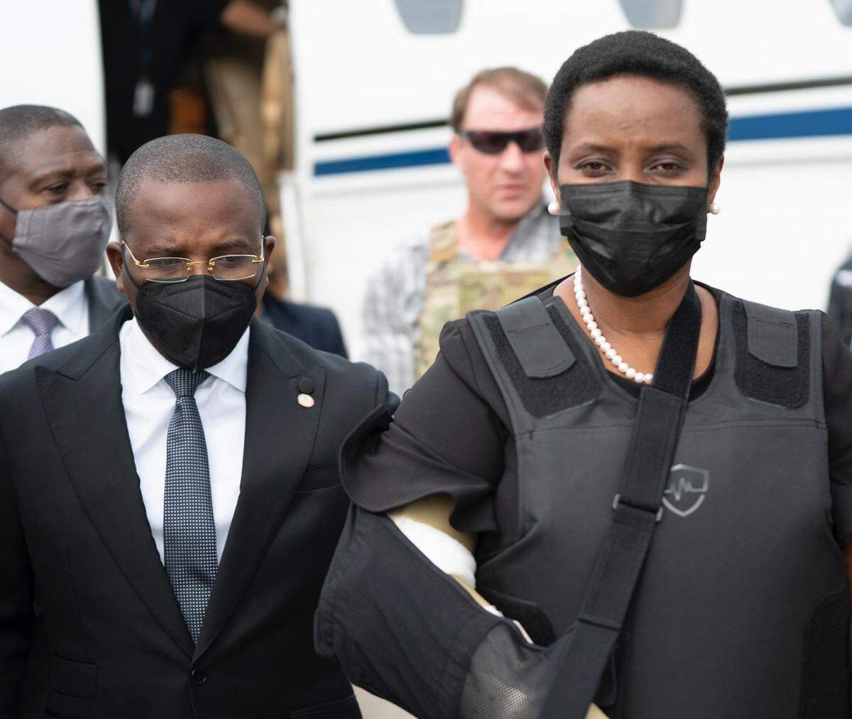 Acting Haiti Prime Minister Claude Joseph escorts an emotional Martine Moïse, the first lady of Haiti, upon her return to the country on July 17, 2021 from Miami on July 17, 2021. Moïse arrived at the Toussaint Louverture International Airport in Port-au-Prince after being wounded in the July 7 attack that killed her husband, President Jovenel Moïse.
